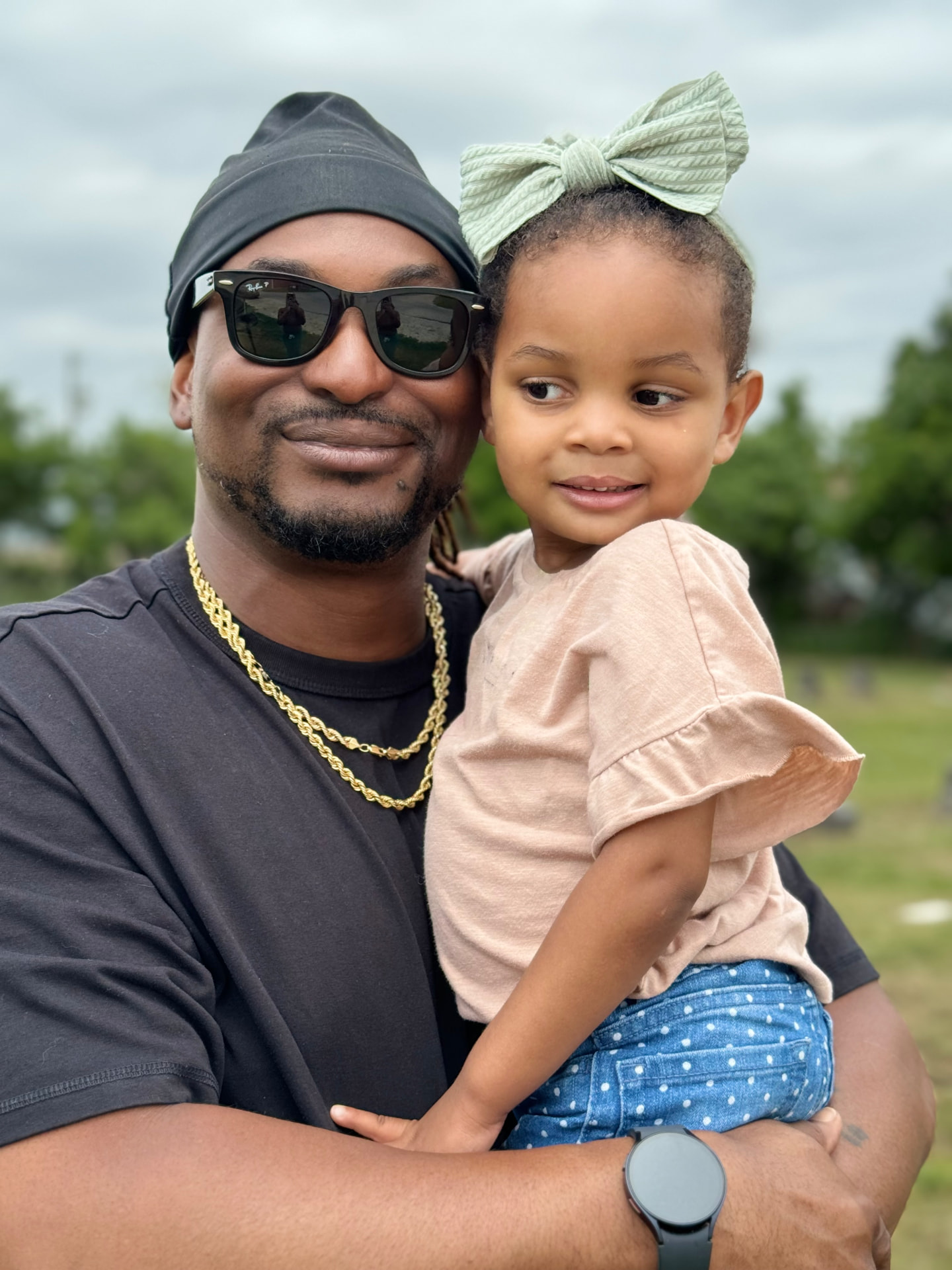 Cliffton L. Styles, founder and executive director, holding his young daughter at the historic cemetery