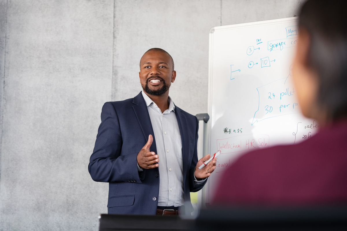 An instructor leading a skills training session at a whiteboard